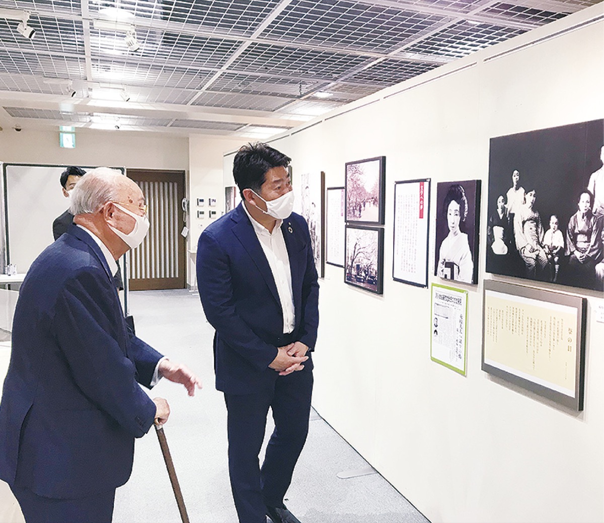 写真に見入る福田市長(右)と斎藤会長