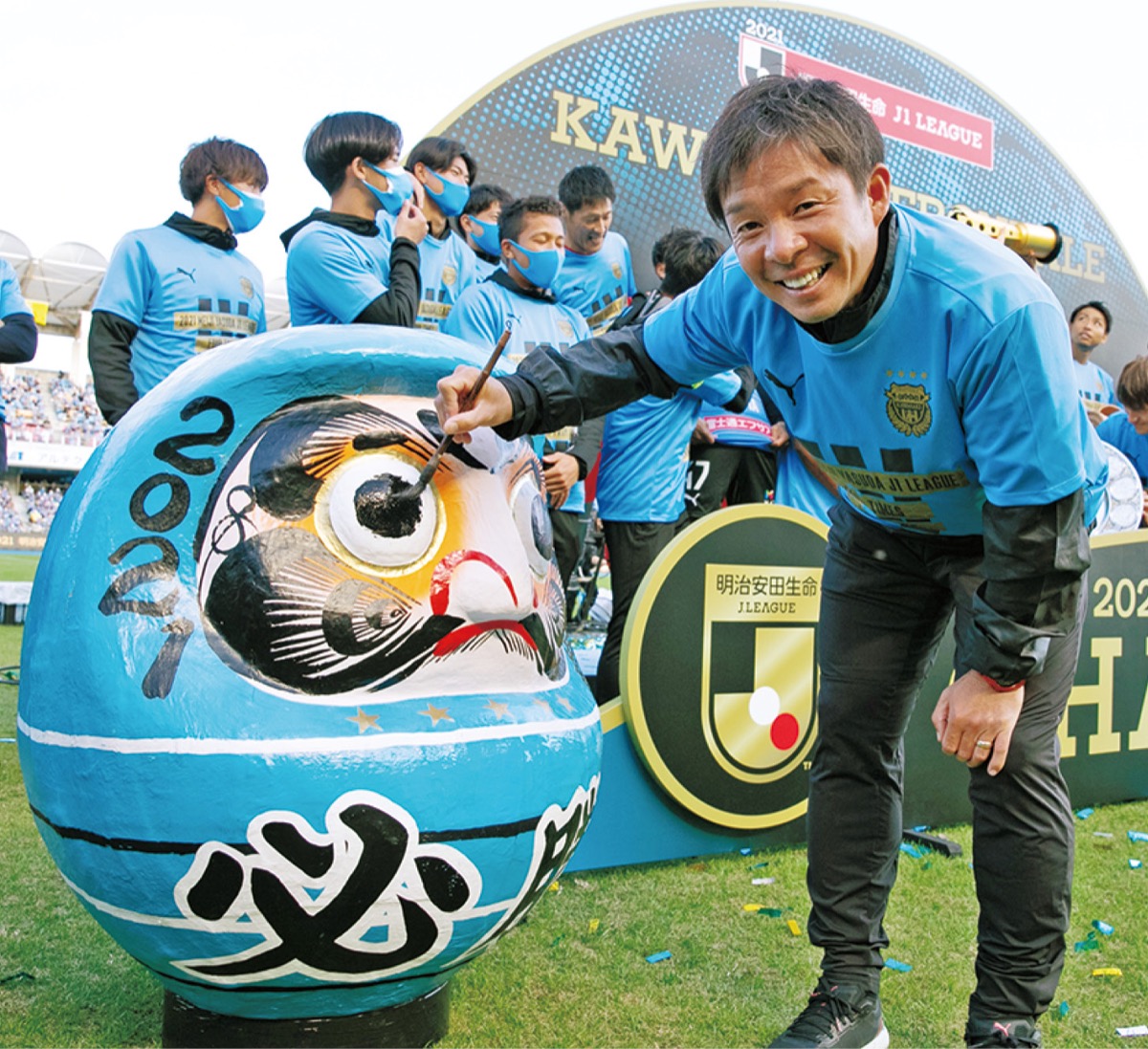 必勝だるまに目入れする鬼木監督