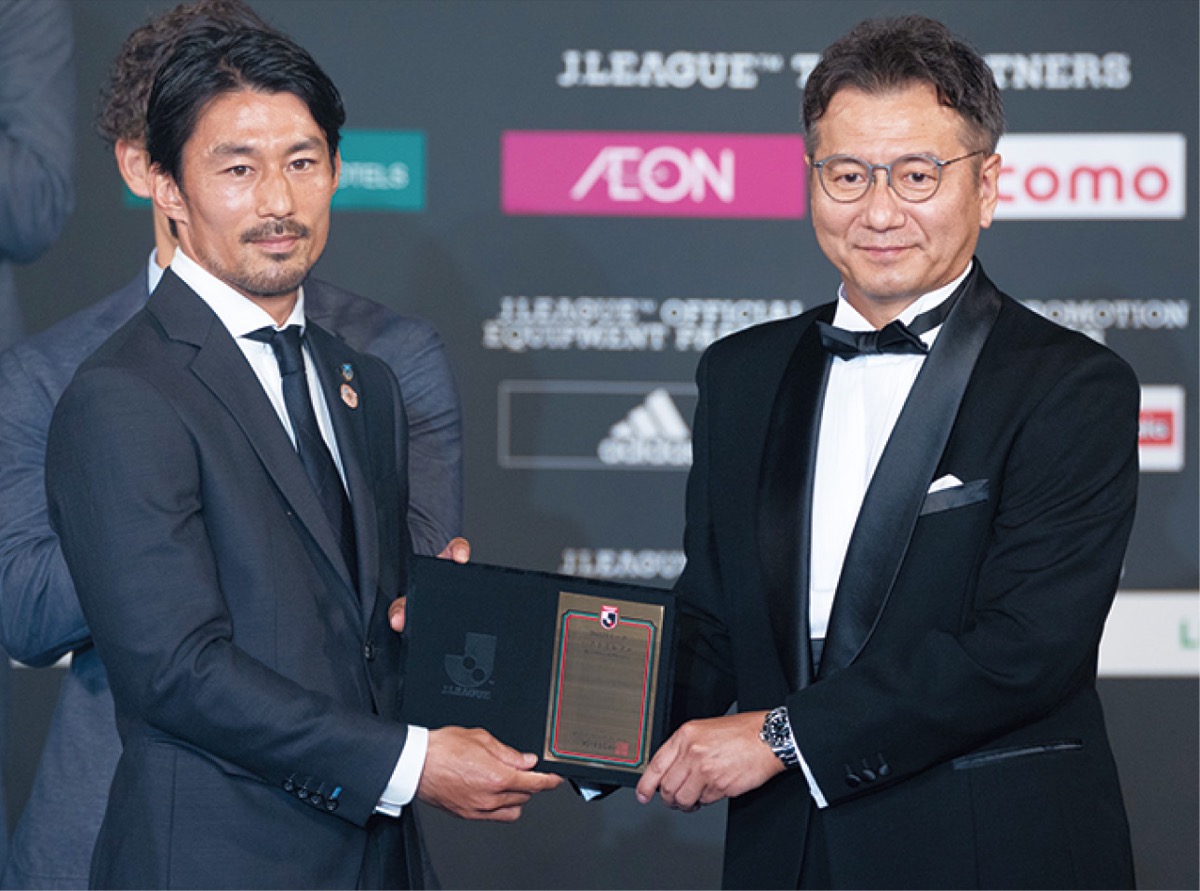 ベストイレブンに選ばれ、盾を受け取る家長選手（左）