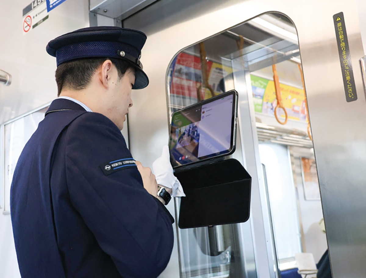 タブレット端末を通じて状況を伝える車掌=京急電鉄提供