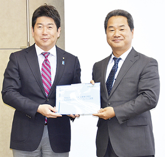 福田市長（左）に報告書を手渡す渡邉代表取締役