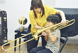 学生から楽器の使い方を教わる子ども