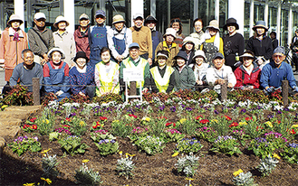 植え替えた花壇の前に集まったフローラかわさきのメンバー