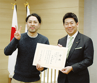 福田市長から表彰され笑顔を見せる店主の佐藤さん（左）