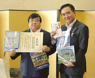 ファイルを披露した伊坂会長（左）と黒岩県知事