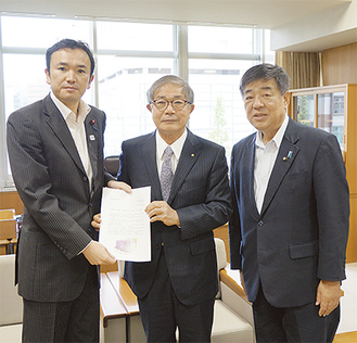 要請書を手にする関係者（左から石田川崎市議会議長、比嘉会長、飯塚議員）