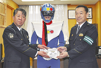（左から）鈴木さん、同校のキャラクター信号マン、伊藤守署長