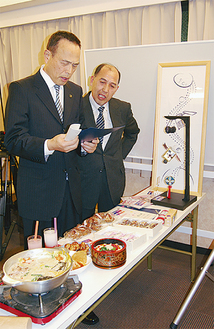 加山市長（左）にはやぶさグッズを紹介する茅明夫商店街理事長