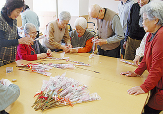 ケアハウスでは入居者12人が花束作りに参加。被災者への想いを込めたメッセージボードも作成された