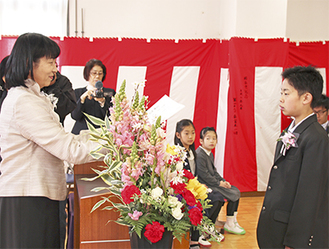 須藤ゆかり校長（左）から卒業証書を受け取る天野武蔵くん＝3月22日、青根中学校内の集会室で