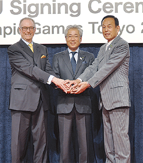 手を取り合う（左から）カルロス・ヌズマンBOC会長、竹田恆和JOC会長、加山俊夫市長