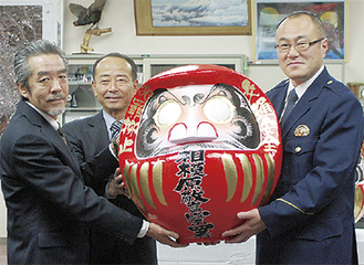 だるまを贈呈した川田勝啓同組合副理事長（左）・小林充明同会会長（中央）と信澤副署長