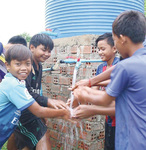 同団体が支給した水道を使うカンボジアの中学生たち＝今年４月