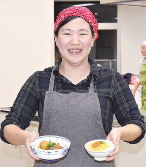 子ども食堂で提供する料理を手に笑顔の六田さん