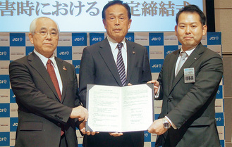 協定書を持つ（左から）戸塚会長、加山市長、小山理事長