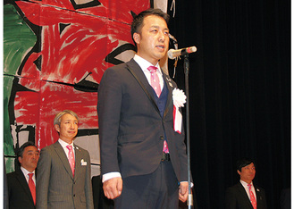 壇上で「五十周年宣言」を行う松下龍太50周年記念事業実行委員長（中央）