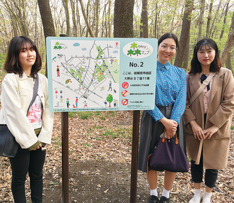 緑地内16カ所に設置された案内看板を見学に訪れた（左から）半田さん、鴨治さん、ユンさん＝6日、木もれびの森