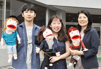 ＭＶに登場した手作り人形を掲げる斎藤さん、澁谷さん、杉森教授（左から）