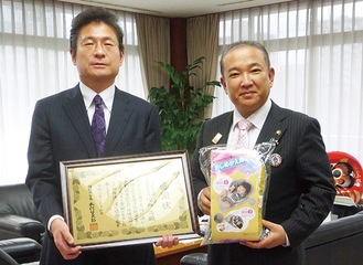 ｢おしめかえ隊」を持つ本村賢太郎市長（右）と佐和代表