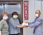 【上写真】作業所のスタッフに手作りマスクを手渡す星が丘地区社協会長の坂本洋三さん（右）