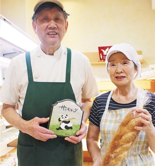 自家製のフランスパンを手にする道子さん（右）と黒田さん
