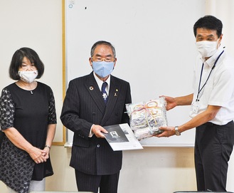 マスクを受け取る花田教頭（右）と山口会長（中央）、内山代表