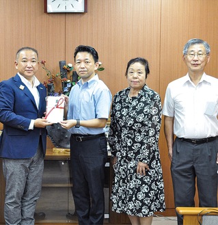 本村市長（左）に寄付金を手渡す教会長の関谷さん(左から２人目)と同教会メンバー