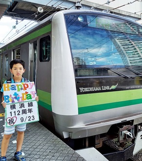この日のために作製したプラカードを手に仲良くＪＲ横浜線と並ぶ慶人くん=9月22日、ＪＲ東神奈川駅