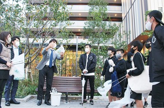 塚原会長（左から３人目）から清掃活動の指示を受ける黒いジャージを着た選手ら（右）