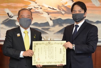 本村市長（左）から感謝状を受け取る山本社長