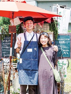 移動販売車の前で笑顔の尾崎店主と妻の紗矢香さん