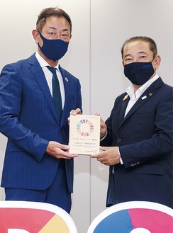 市役所で7月28日に行われた「さがみはらSDGsパートナー登録証盾交付式」で本村賢太郎市長から盾を受け取る赤間理事長（左）