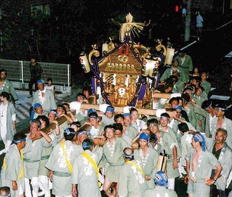 例大祭で神輿を担ぐ人々＝総代提供（2004年撮影）