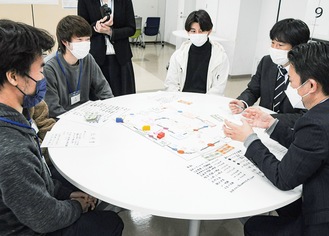 さまざまなテーマで製作した地域課題解決の「シリアスゲーム」に学生と共に取り組んだ市職員ら＝19日、多摩大学（東京都多摩市）の多摩キャンパス