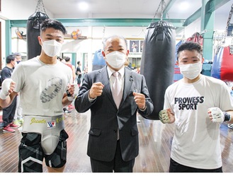 中谷選手（左）、石澤選手（右）の2人のチャンピオンとファイティングポーズで撮影に応じる本村市長＝4日、M.Tジム