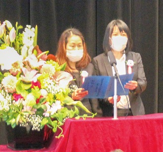 開校式で生徒を代表し、壇上でスピーチする北さん（左）と王さん＝4月23日