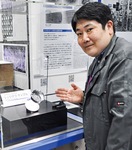 宇宙科学探査交流棟に展示されたリュウグウ試料を紹介するJAXA広報の大川拓也さん