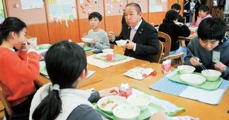 交流を楽しみながら給食を頬張る子どもたちと本村市長