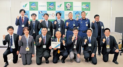 報告会でのチームメンバーと本村市長（前列中央）