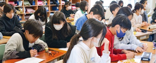 リボンに自分の考えを書く宮上小６年１組の児童たち。中にはピンクの服を着て登校してきた児童も