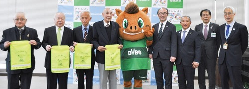 ランドセルカバーを手にする交通安全協会の会長たちと｢ダイボ君｣（中央）、本村市長（右から３人目）