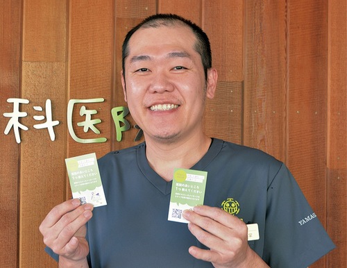 メッセージ依頼のカードを持つ山下院長