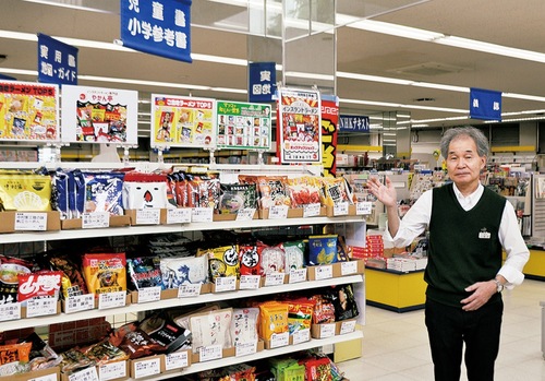 ご当地ラーメンの特設棚を案内する飯田店長