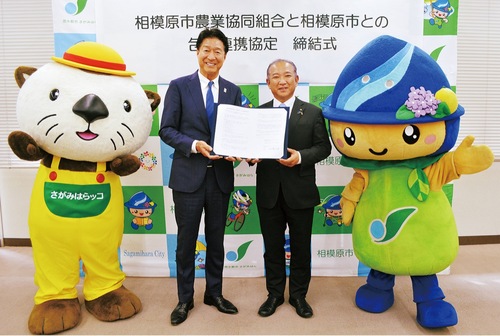 協定書を手にする落合代表理事組合長と本村市長