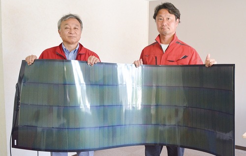 曲がる太陽電池を持つ栗谷川社長と友清取締役