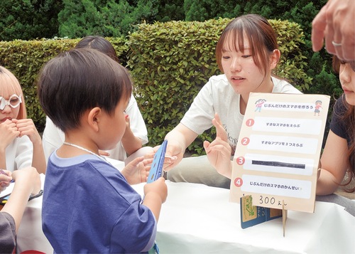 「スマホやさん」でアプリを選ぶ子ども