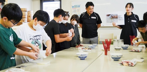 社員や子ども食堂のスタッフが見守る中、防災食を調理する児童たち