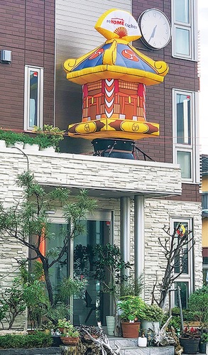 玄関アプローチの屋根に設置された神輿バルーンが祭りの開催を告げている