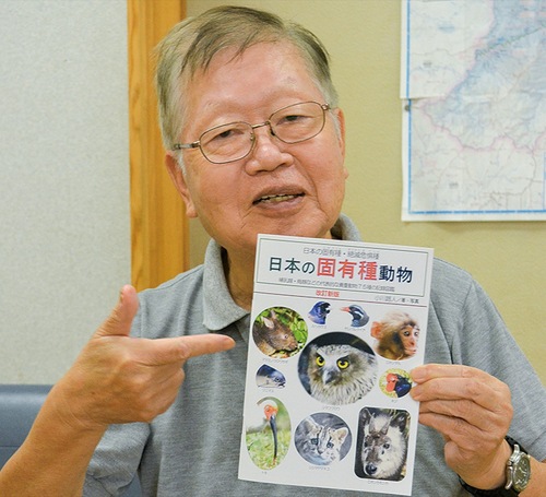 図鑑を手に笑顔の小川さん