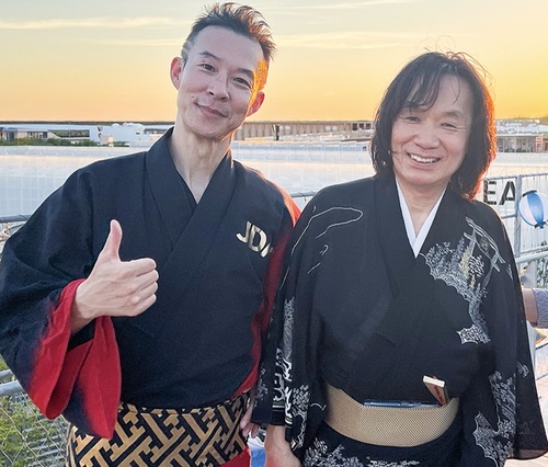 大屋根リングで河内家菊水丸師匠（右）と共に笑顔を見せるのりんご☆さん（本人提供）